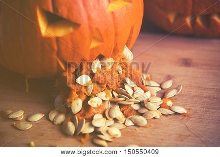 Close Up On Pumpkin Puking With Pumpkin Seeds On Wood Table