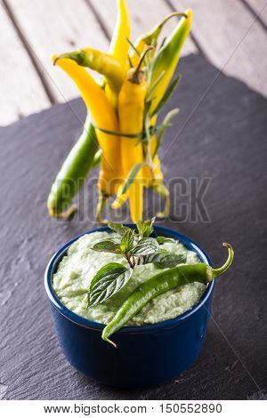 Blue Bowl With Wasabi Dip And Several Chili Peppers
