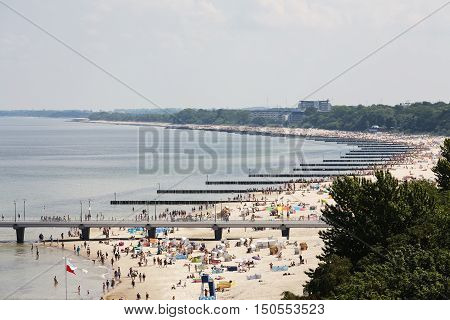 KOLOBRZEG POLAND - JUNE 22 2016: The coastline of the Baltic Sea along many breakwaters were placed that protect the beach against effects of sea waves. Many sunbathers can see there.