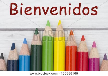 Pencil Crayons with text Bienvenidos Spanish for Welcome with weathered wood background