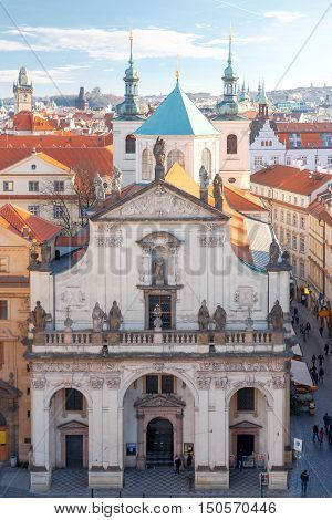 Aerial view of the historic center of Prague with towers, spiers and red-tiled roofs.