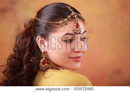 beautiful Indian woman in a sari traditional dress on an abstract yellow background