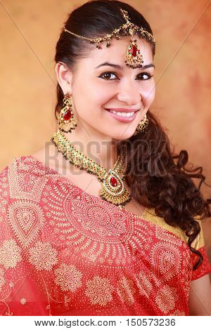 beautiful Indian woman in a sari traditional dress on an abstract yellow background