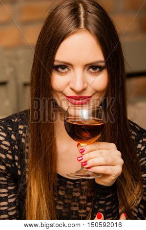 Woman Tasting Wine In Rural Cottage Interior