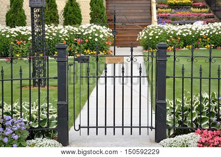 A cast iron gate keeps the public out of a private yard.