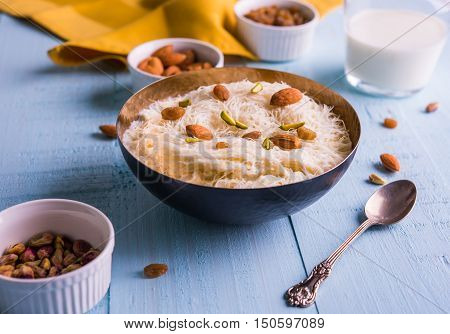 Indian sweet sutarfeni or sutar feni or firni or seviyan or laccha, shredded, flaky-rice-flour roasted in ghee, blended with melted sugar to form a cotton candy, topped with pistachio and almonds