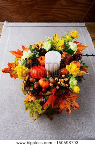 Fall decoration with candle and silk maple leaves vertical. Thanksgiving greeting with fall decor. Fall centerpiece. Thanksgiving background.