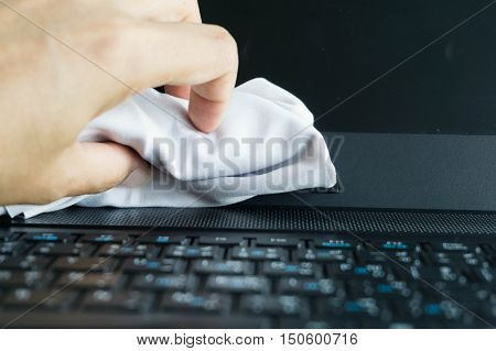 Young woman hands cleaning laptop computer screen.
