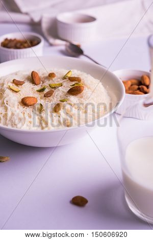Indian sweet sutarfeni or sutar feni or firni or seviyan or laccha, shredded, flaky-rice-flour roasted in ghee, blended with melted sugar to form a cotton candy, topped with pistachio and almonds