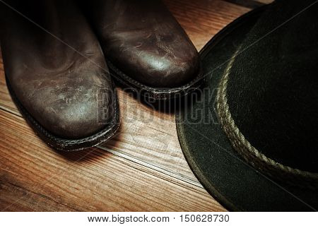American West rodeo cowboy dirty and used brown botts and hat