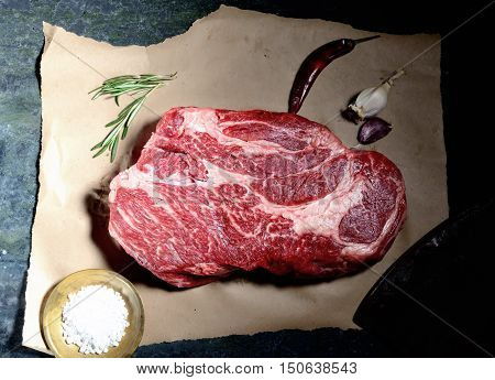 veal steak marbled paper, knife for meat, rosemary, pepper and salt
