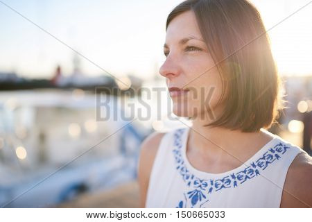 Attractive mature white woman busy looking off camera early in the morning with brwon hair cut in a bob style with copy space to one side.