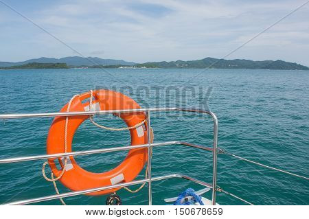 Orange life preserver (or Life Buoy)on luxury sailing yacht with beautiful blue sky cloud and Andaman sea background in sunny dayPhuketThailand