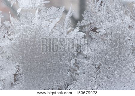 Closeup of fancy openwork frosty pattern on winter window glass.