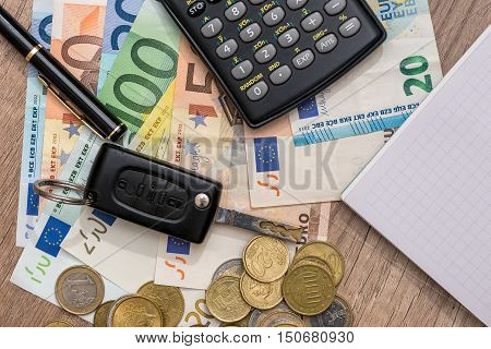 car key euro banknotes pen coins and notebook