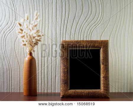 Ikebana og vintage fotoramme på bordet