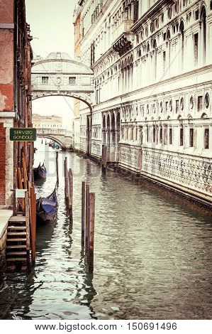 Photo of the Bridge of Sighs (Ponte dei Sospiri ) with gondolas dock in Venice (Italy). Photo is edited as a vintage with dark edges.