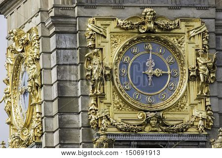 An ornate and ostentatious gold clock at 3pm