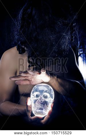 Primitive looking man in a dark smoky forest as a witch doctor or shaman