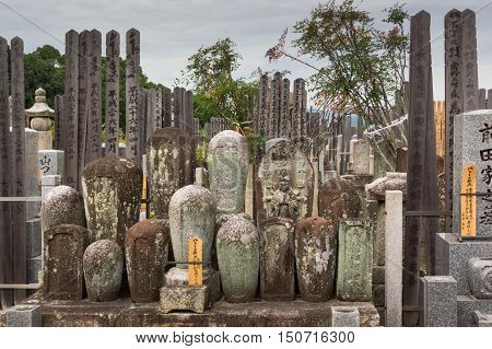 Kyoto Japan - September 15 2016: Adjacent to the Shinnyo-do Buddhist Temple is a large cemetery serving the Buddhist community. A group of old cylindrical tombstones are set together.
