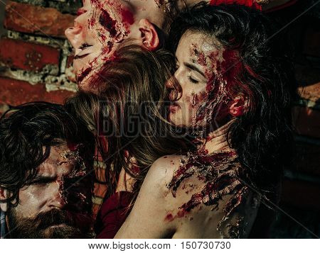 young halloween zombie people. bearded man with and sexy pretty girls with red blood and wounds as traditional autumn holiday symbol