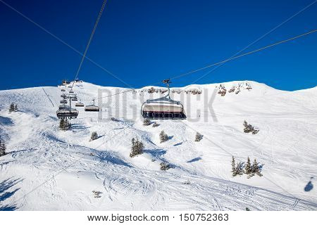 KITZBUEHEL AUSTRIA February 18 2016 - Skiers on ski lift enjoying the view to foggy Alps in Austria and beautiful snowy country panorama in famous Kitzbuehel mountain ski resort