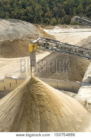 Working belt conveyors and a piles of rubble and stone meal in Gravel Quarry