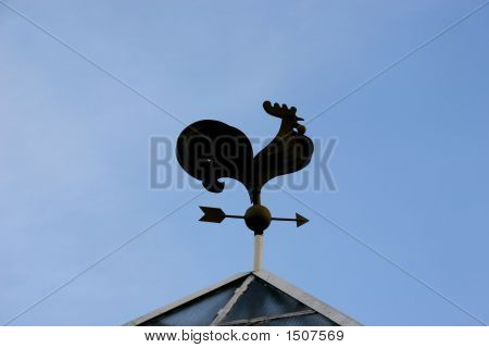 Silhuet af Weathercock Over blå himmel