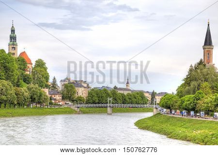 SALZBURG AUSTRIA - May 05.2012: City landscape. Salz River and the spiers of the Catholic Church on its banks