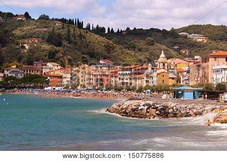 The village of San Terenzo (St. Terenzo) with the beach crowded with sunbathers. Lerici in the Gulf of La Spezia Liguria Italy