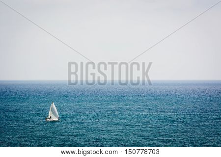 A sailboat sailing by sea on a foggy day