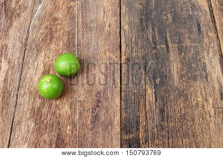 lemon with green on the wooden table top view