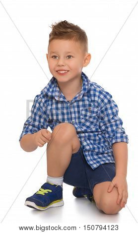 Happy little boy in shirt and shorts kneeling on the floor. He expresses his emotions - Isolated on white background