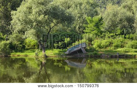 An old beached boat on land in Virpazar next to Skadarsko Jezero or Lake Skadar in Montenegro.