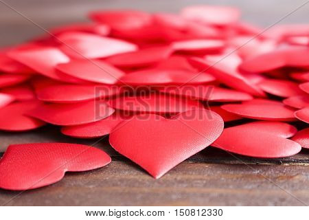 Bulk lot of red hearts on a wooden table.Love, romance, wedding, engagement, Valentine's day.