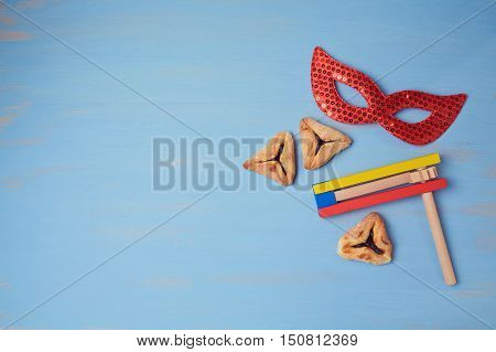 Jewish holiday purim background with carnival mask and hamantaschen cookies. View from above