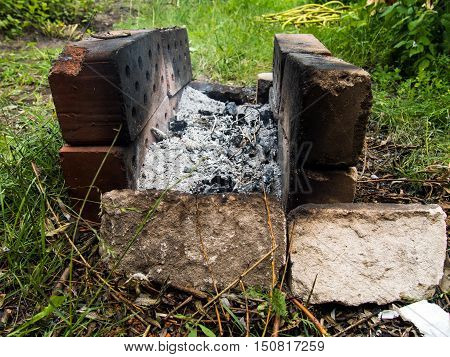 Homemade brazier of old bricks on the grass