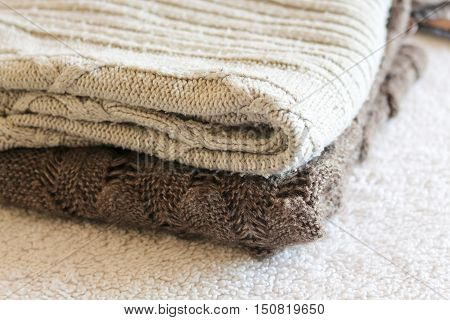 Stack of cozy knitted warm sweater on your home background . Sweaters in retro Style. The concept of warm .