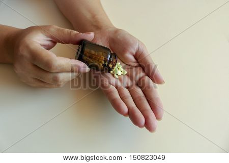 A young woman pours the pills out of the bottle