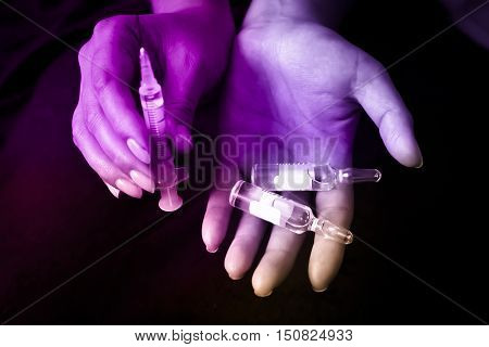 Stabbing drugs. the syringe and the hand enters injections, drugs, doping.
