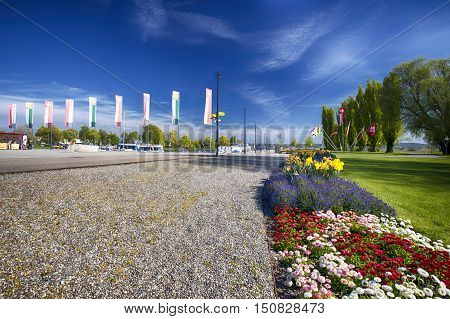 Flags and flowers alond embarkment in the Kreuzlingen city center near Konstanz city with the lake Constance and boats in the background Switzerland.