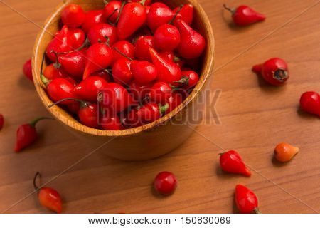 Biquinho Pepper into a bowl. Capsicum Chinense over a wooden table