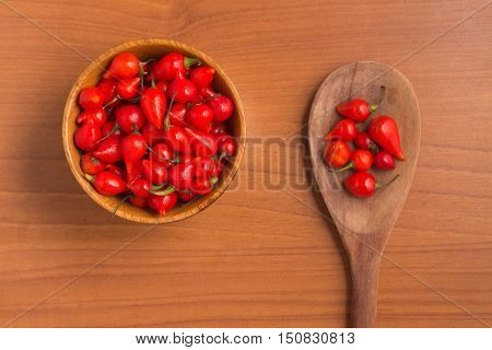 Biquinho Pepper into a bowl. Capsicum Chinense over a wooden table