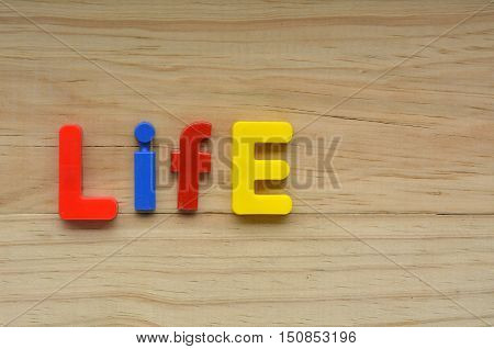 Top Lay Of The Word Life On A Wooden Background