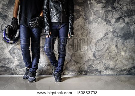 Biker man and women wearing jeans and leather jecket with helmet and glove