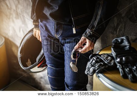 Biker man wearing jeans and leather jecket with helmet and glove