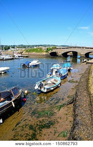 AXMOUTH, UNITED KINGDOM - JULY 18, 2016 - Fishing boats moored in the harbour with the stone bridge to the rear Axmouth Devon England UK Western Europe, July 18, 2016.