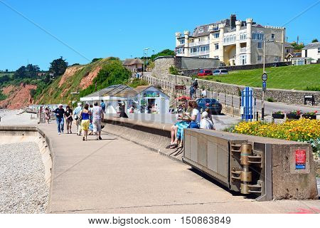 SEATON, UNITED KINGDOM - JULY 18, 2016 - Holidaymakers walking along the promenade with the beach to the left hand side Seaton Devon England UK Western Europe, July 18, 2016.
