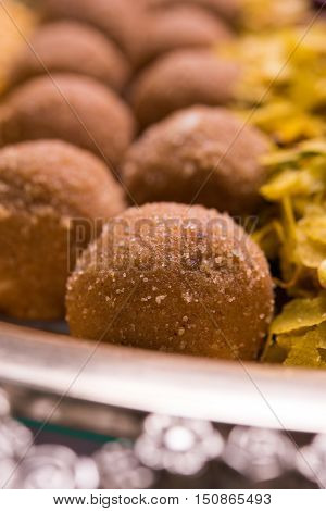 Plate full of indian festival food or diwali food or snacks like laddu, chivda, chakali or murukku, sev and shankar pale, sweet and salty snack food