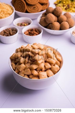 home made tasty Diwali food or Diwali snacks or Diwali sweets like rava laddu, chakli, sev,shankar pale and chivda or chiwada with dry fruits in white bowls, favourite indian diwali recipe